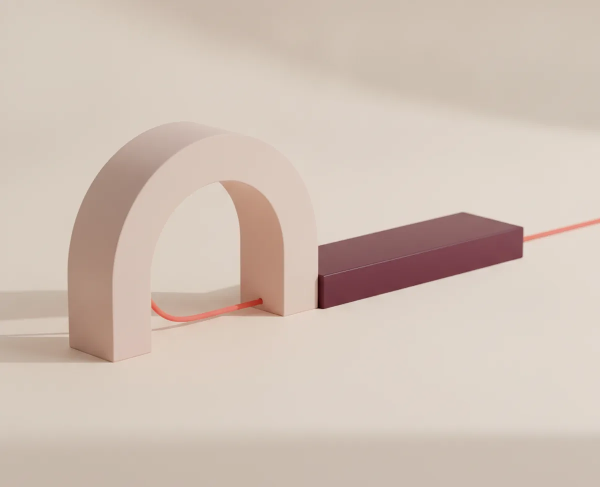 A coral thread running across a warm off-white floor, passing under a matte blush arch and through a low burgundy block before continuing away to the right